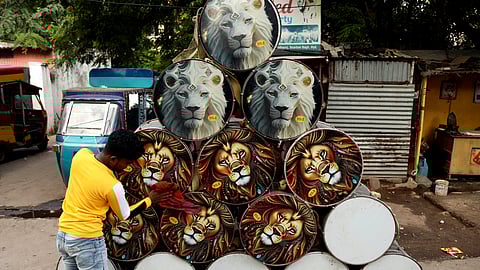 A vendor cleans the drums kept for rental ahead of Ganesh Chaturthi at Dhoolpet in Hyderabad on Tuesday.
