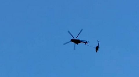 A Crystal Company's helicopter that had met with an accident and was being taken to the Gauchar airstrip by Indian Army's MI-17 helicopter, falls down after losing its balance, at Kedarnath in Rudraprayag district, Saturday, Aug 31, 2024. 