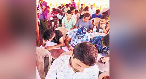 Migrant labourers during an exam conducted by the Literacy Mission 