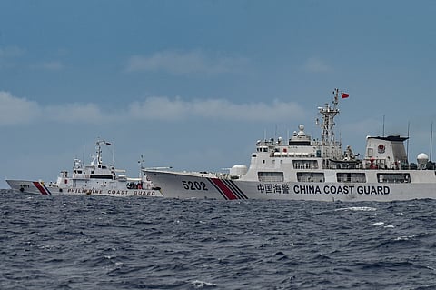 A China Coast Guard ship (R) is seen past the Philippine Coast Guard ship BRP Cape Engaño (L), as photographed from the BRP Cabra during a supply mission to Sabina Shoal in disputed waters of the South China Sea on August 26, 2024. 