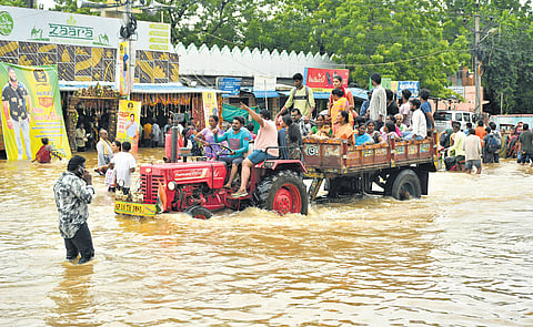 People being rescued from the flood affected areas of Singh Nagar in Vijayawada in a tractor on Sunday| 