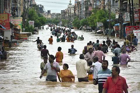 Residents of Singh Nagar wade through the flood after the Budameru canal breach in Vijayawada, a year back.