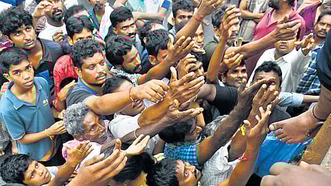 People throng a distribution centre, where food and buttermilk were being given to the flood-affected residents at Chitti Nagar in Vijayawada