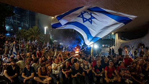 People block a road as they protest, calling for a deal for the immediate release of hostages held in the Gaza Strip by Hamas, in Tel Aviv, Israel.