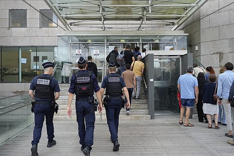 Police officers walk in the Avignon court house prior to the trial of Dominique Pelicot, in Avignon, southern France, Thursday, Sept. 5, 2024. 