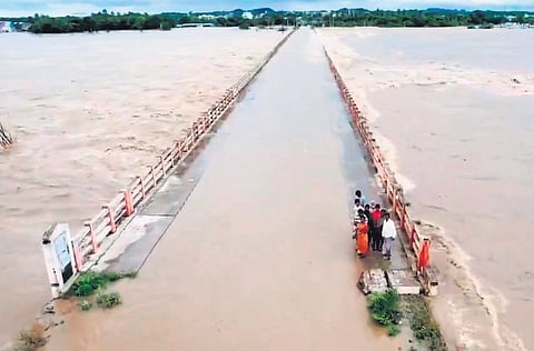 File picture of people stranded on a bridge on Munneru river during the recent floods