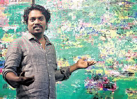 Artist Sridhar, with his artworks displayed at the exhibition in Puducherry 
