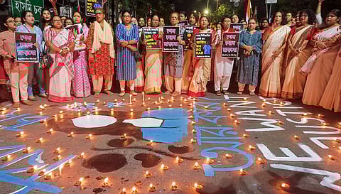 Women hold posters during an early morning protest against the alleged sexual assault and murder of a trainee doctor at Kolkata's RG Kar Medical College and Hospital, in Siliguri, Monday, Sept 9, 2024.