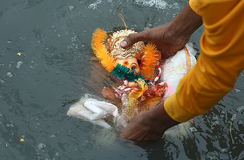 A man immerses the idol of Lord Ganesha at People's Plaza in Hyderabad. 