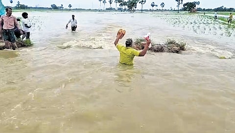 People were forced to wade through water following the breach to Yeleru Canal at Gorrikandi village in Pithapuram mandal of Kakinada district| express