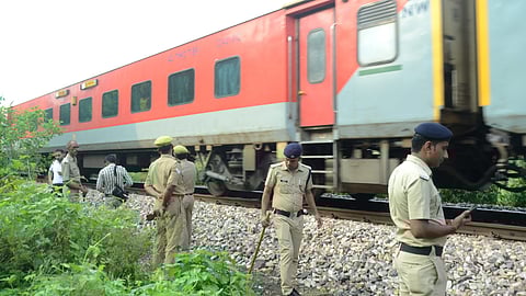 Police personnel keep vigil near the site as a train passes by after an attempt was allegedly made to derail the Kalindi Express, heading towards Bhiwani from Prayagraj.