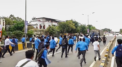 Members of All Manipur Students' Union (AMSU) charge towards a CRPF convoy during a protest march against the recent violence in the state, in Imphal.