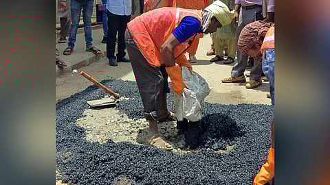 A BBMP worker fills a pothole with tar in Bengaluru.