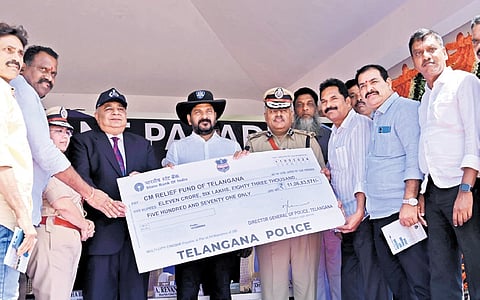 DGP Jitender hands over a cheque towards flood relief of Rs 11.68 crore to Chief Minister A Revanth Reddy on behalf of the state police on Wednesday.