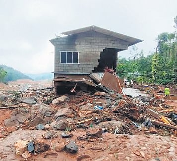 A damaged house stands amid the debris at Mundakkai 