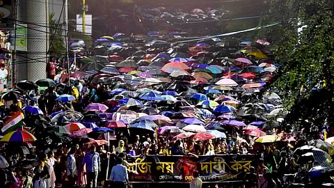Junior doctors take part in a protest march to Swasthya Bhavan over the alleged sexual assault and murder of a trainee doctor, amid rain, in Kolkata.
