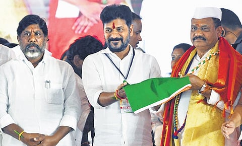 Chief Minister A Revanth Reddy hands over the party flag to MLC B Mahesh Kumar Goud, who assumed charge as TPCC president at Gandhi Bhavan in Hyderabad on Sunday. Deputy Chief Minister Mallu Bhatti Vikramarka is also seen