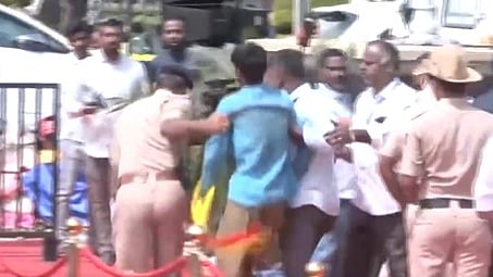 The person wearing a red and yellow Kannada flag-like scarf, manages to throw a shawl towards the CM