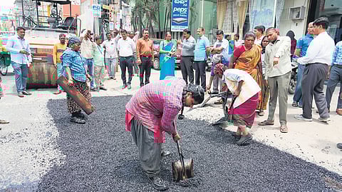 BBMP workers fill a pothole in Bengaluru on Monday