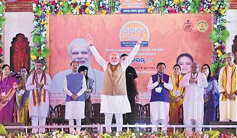 PM Modi waves to the crowd during the launch of Subhadra Yojana in the presence of CM Mohan Majhi and Union minister Dharmendra Pradhan
