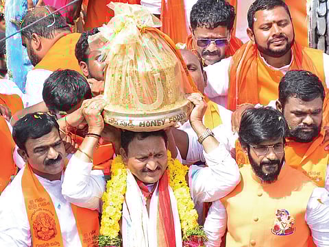 Local BJP leader Kolan Shankar Reddy carries the 21-kg laddu on his head in Balapur on Tuesday