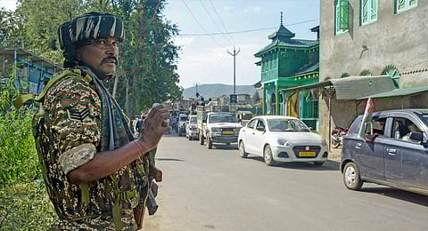A security personnel stands guard during a roadshow of MP and Awami Ittehad Party chief Sheikh Abdul Rashid in support of party candidate from Tral constituency Harbaksh Singh ahead of J&K Assembly elections, at Tral area in Pulwama district, Jammu & Kashmir, Sunday, Sept. 15, 2024. 