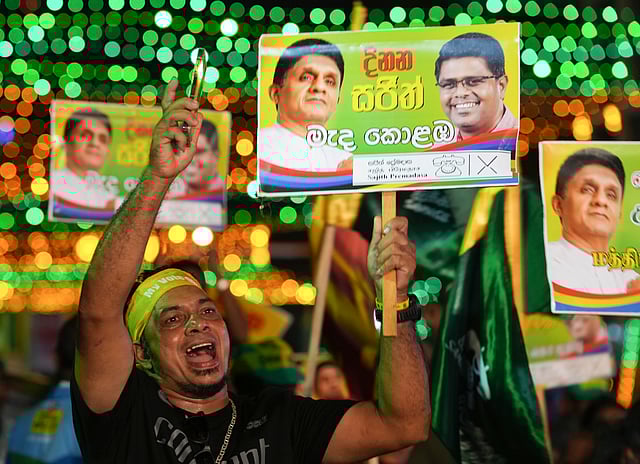 A supporter of presidential candidate of Samagi Jana Balawgaya or United People's Power and opposition leader Sajith Premadasa cheers holding his banner during the final campaign rally ahead of the presidential election in Colombo.