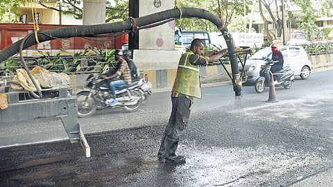 A BBMP worker fills a pothole near RR Metro station on Thursday | Vinod Kumar T