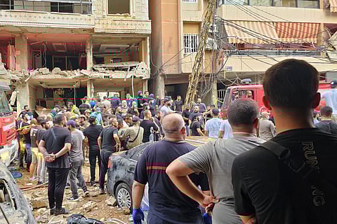 Residents look on as rescuers arrive at the scene of an Israeli missile strike in the southern suburbs of Beirut, Friday, Sept. 20, 2024.