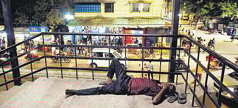 A man, inebriated, lying on the stairs of Perambur Railway Station, after consuming alcohol from a Tasmac outlet located right next to the entrance