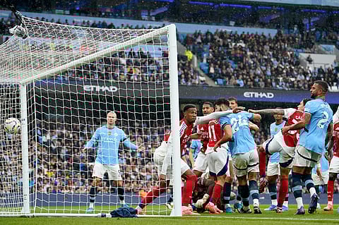 Manchester City's John Stones, center, scores his side's second goal during the English Premier League soccer match between Manchester City and Arsenal at the Etihad stadium in Manchester.