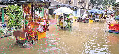 Vendors on a waterlogged street after water level of River Hooghly in Kolkata.