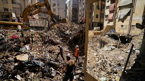 Emergency workers use excavators to clear the rubble at the site of Friday's Israeli strike in Beirut's southern suburbs, Lebanon.