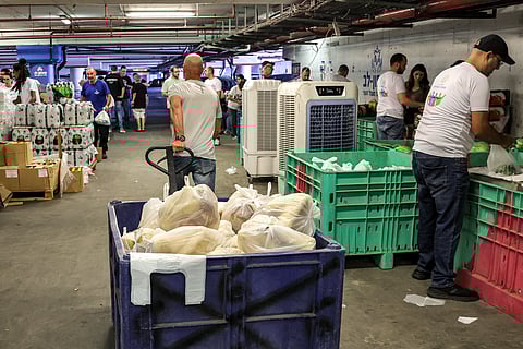 Israeli volunteers from the "Pitchvon Lev" association, distribute food bags to people in an underground parking lot in in Rishon LeZion in central Israel on August 21, 2024, amid the ongoing conflict in the Gaza Strip between Israel and the Palestinian militant group Hamas.