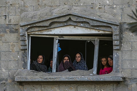  Palestinians look at the destruction after an Israeli airstrike on a crowded tent camp housing Palestinians displaced by the war in Muwasi, Gaza Strip