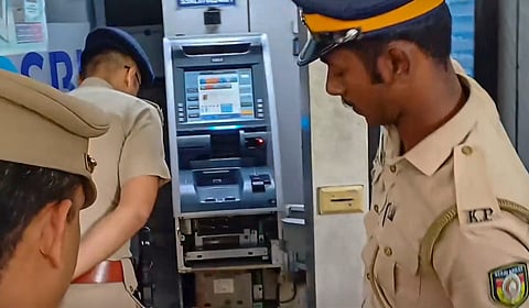 Police personnel inspecting ATM machines from which thieves looted cash