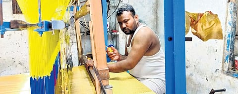 Nalla Vijay Kumar seen weaving the 200-gram golden saree worth Rs 18 lakh, unveiled in Sircilla on Saturday