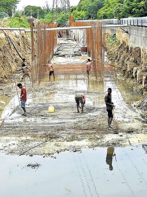 Workers seen constructing the storm water drain along the GST road at Padi.