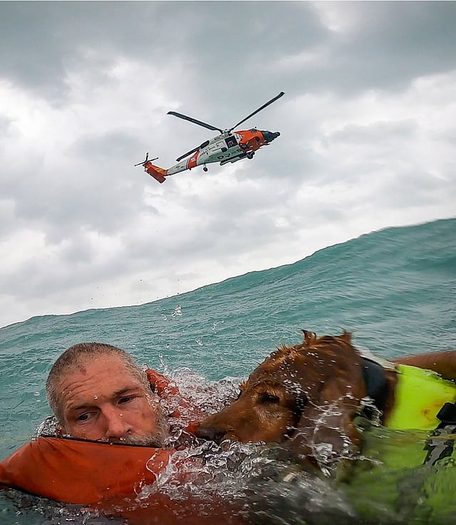 This photo provided by U.S. Coast Guard District Seven (USCGSoutheast) shows a man and his dog being rescued after his sailboat became disabled during Hurricane Helene approximately 25 miles off Sanibel Island, Florida.