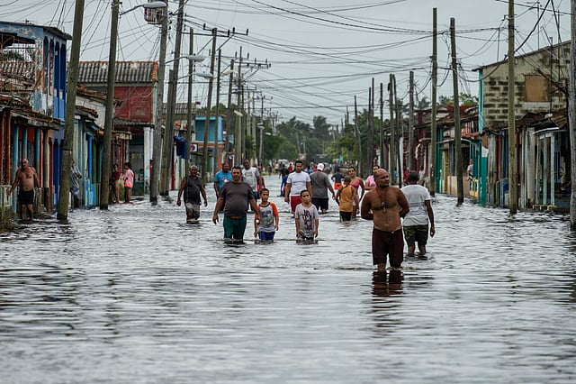 Residents wade through a street flooded in the passing of Hurricane Helene, in Batabano, Mayabeque province, Cuba.