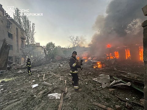 Firefighters put out the fire after Russia attacked the city with guided bombs overnight in Zaporizhzhia, Ukraine on Sunday.