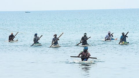 Traditional squid fishermen rowing their thermocol pieces in shallow water
