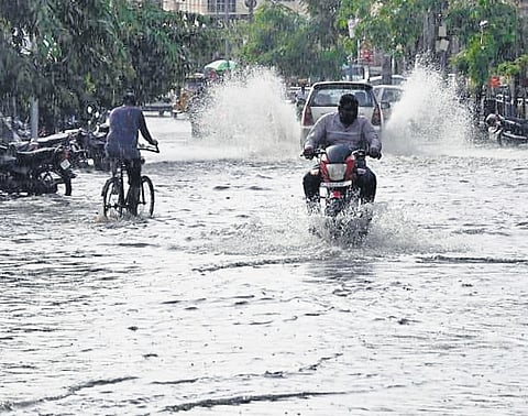 A biker is seen riding on a waterlogged road in Karimnagar on Monday