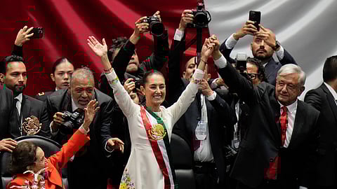 President Claudia Sheinbaum, center, and outgoing President Andres Manuel López Obrador, right, stand before lawmakers on her inauguration day at Congress in Mexico City, Tuesday, Oct. 1, 2024.