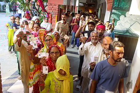 Voters wait in a queue to cast their votes at a polling station during the Haryana Assembly elections, in Rohtak district, Saturday, Oct. 5, 2024.