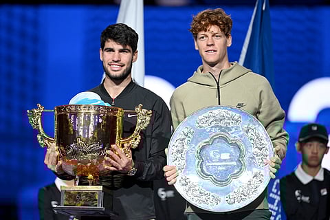 Spain’s Carlos Alcaraz (L) celebrates with the trophy after winning the men’s singles final against Italy’s Jannik Sinner (R) at the China Open tennis tournament in Beijing