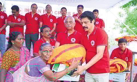 AP Red Cross members distribute relief kits to flood victims on Sunday 