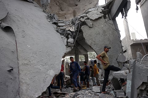 Palestinians check the rubble of a mosque-turned-shelter in Deir al-Balah in the central Gaza Strip, targeted by an Israeli strike 