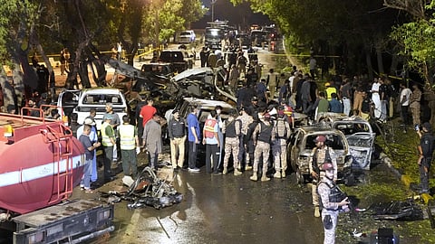 Security officials examine the site of an explosion that caused injuries and destroyed vehicles at outside Karachi airport, Pakistan, Monday, Oct 7, 2024.
