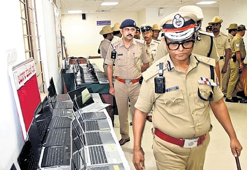 Bengaluru City Police Commissioner B Dayananda takes a look at laptops and currency notes recovered by Kumaraswamy Layout and Halasuru Gate police on Tuesday 